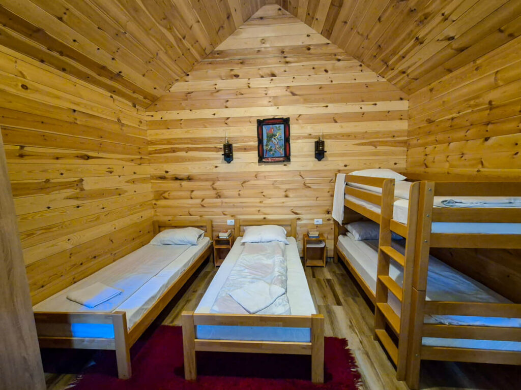 The wooden interior of a cabin in Eko Katun Rosi with two single beds and a bunk bed.
