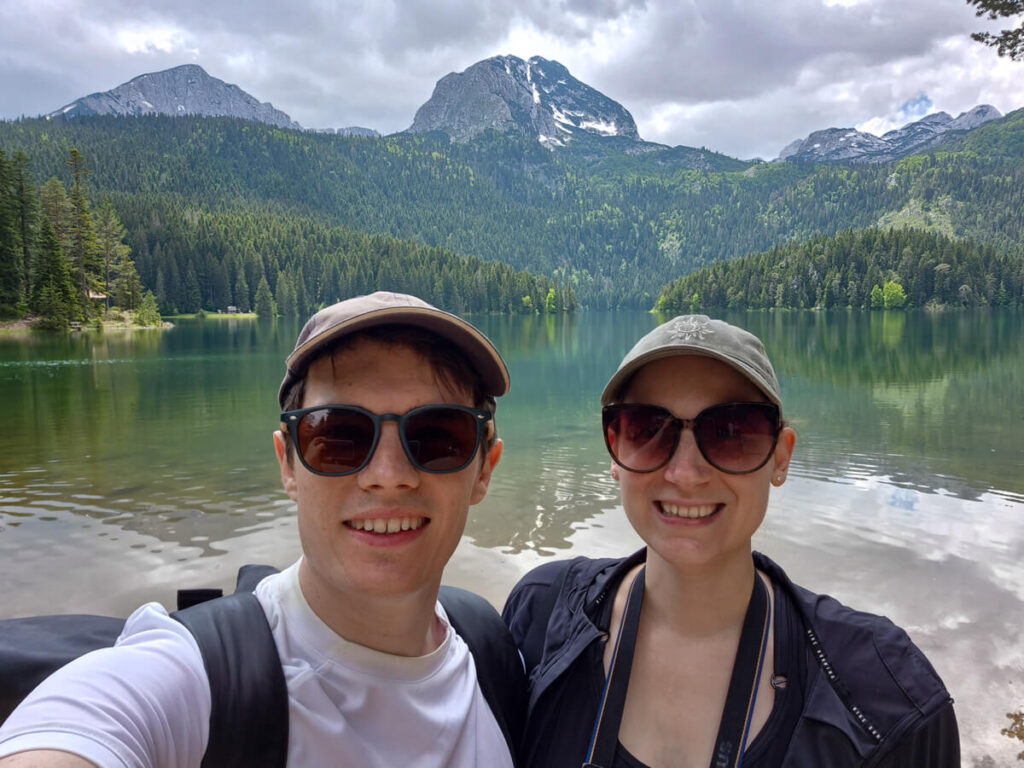 Lucy and Dan smiling in front of the Black Lake in Durmitor National Park.