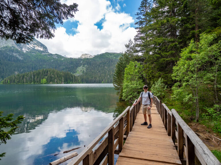 Dan standing on a wooden bridge looking at the Black Lake in Durmitor National Park.