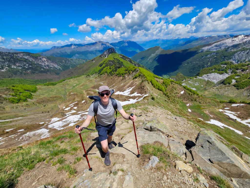 Dan hiking up a steep hill along the ridgeline of the Three Peaks loop in Prokletije National Park.
