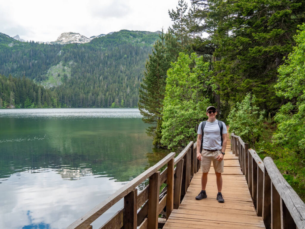 Dan standing on a wooden bridge at the Black Lake in Durmitor National Park.
