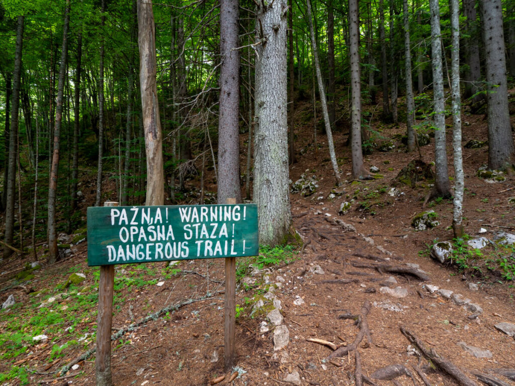 A sign warning of dangerous terrain on the trail at the Black Lake in Durmitor National Park.