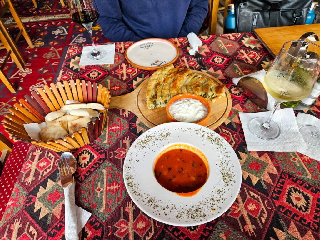 Local dishes of Montenegrin food, including soup, fresh bread, and burek.