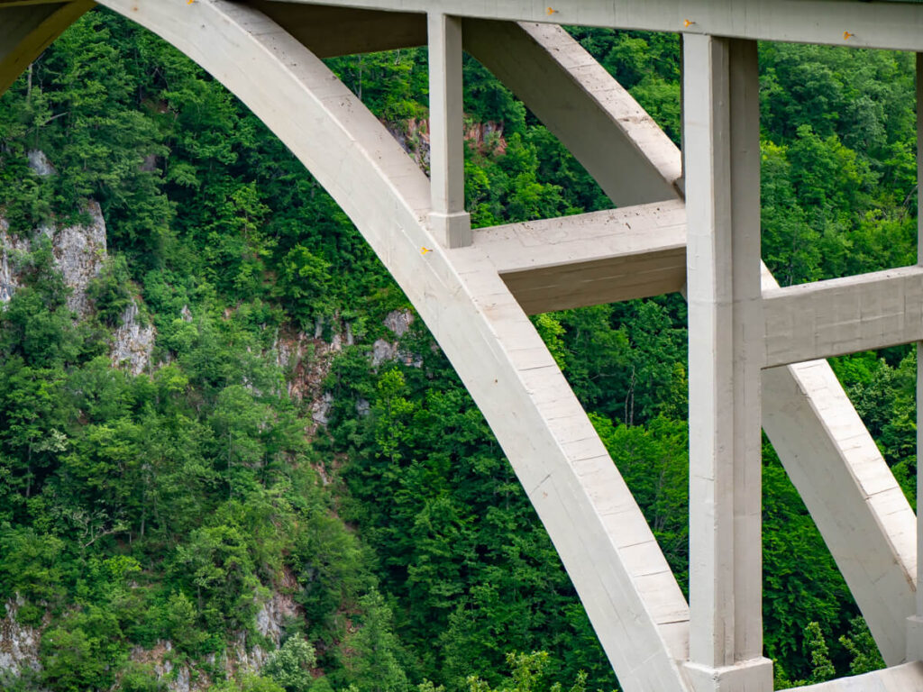 A close view of a concrete arch that holds up Djurdjevica Tara Bridge in Durmitor National Park.
