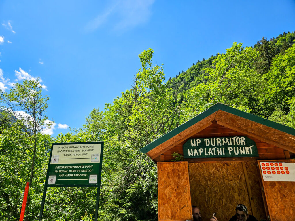 A wooden ticket booth with a sign that reads "NP Durmitor naplatni punkt".