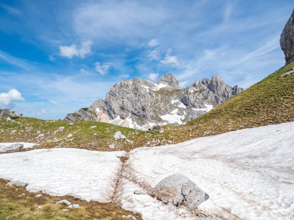 Footprints leading across a snowbank towards Bobotov Kuk.