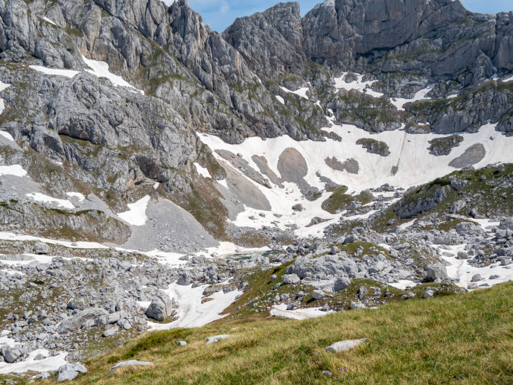 A faint trail leading downhill to a glacial lake at the foot of Bobotov Kuk.