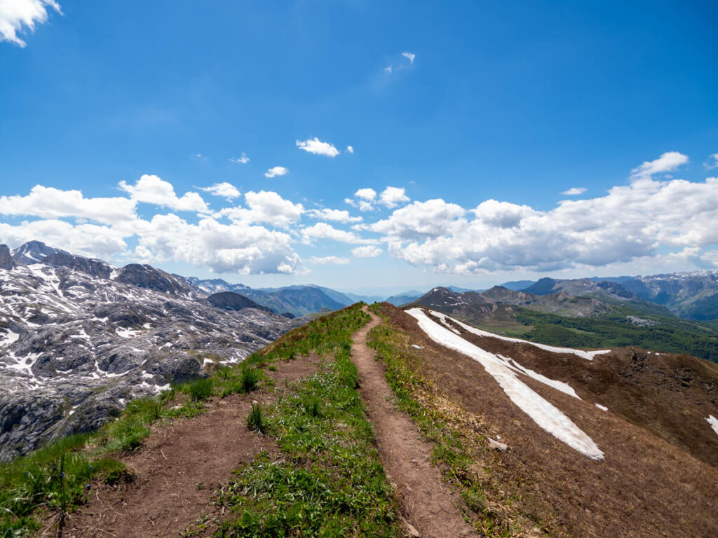A long dirt trail on a narrow ridge with steep sides on the Three Peaks trail in Prokletije National Park.