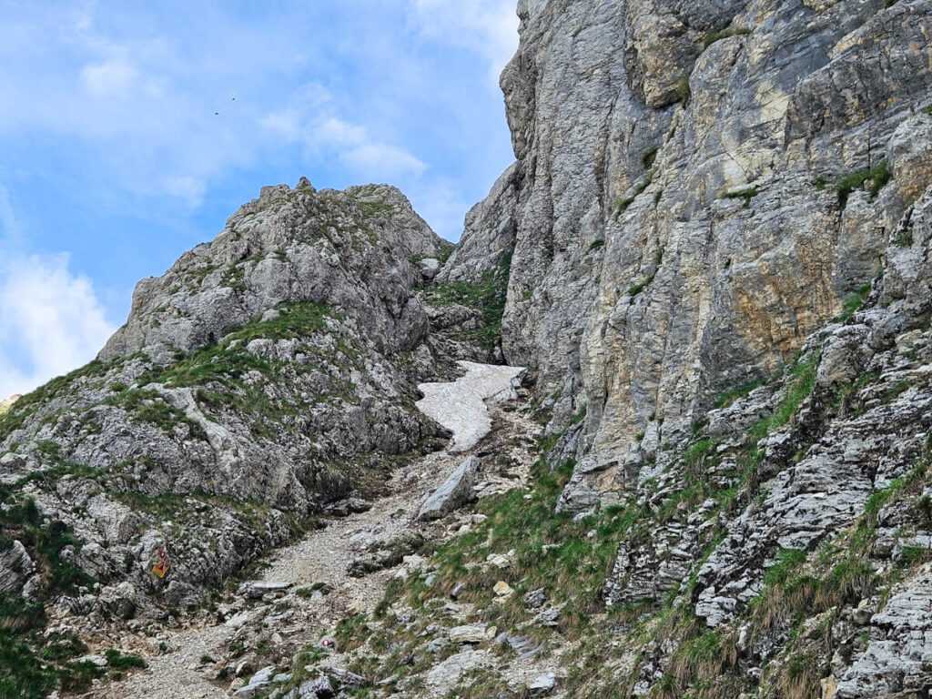 Snow at the base of a small rock scramble section on the Bobotov Kuk trail.