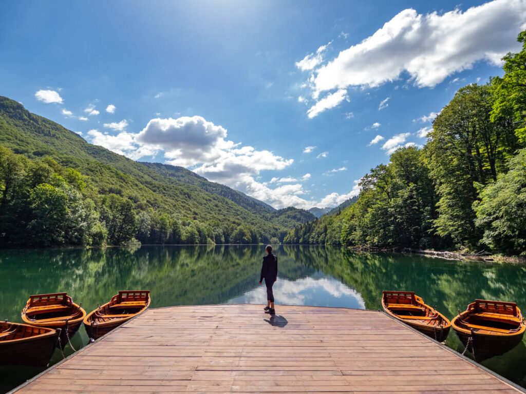 Lucy standing on a wooden dock looking out over Lake Biograd in Biogradska Gora National Park.