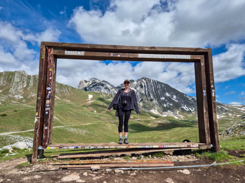 Lucy standing on a frame at a viewpoint of Prutaš on the Durmitor Ring Road.
