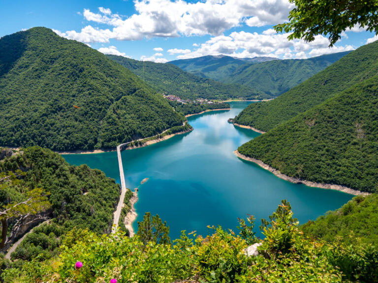 A wide, sweeping view of Piva Lake on a sunny day in Montenegro.