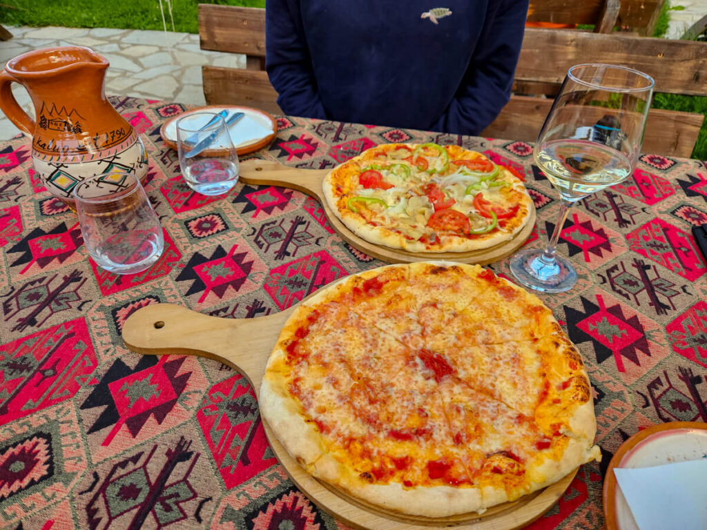 Two pizzas on a wooden paddle on a patterned tablecloth in the restaurant at Eko Katun Rosi.