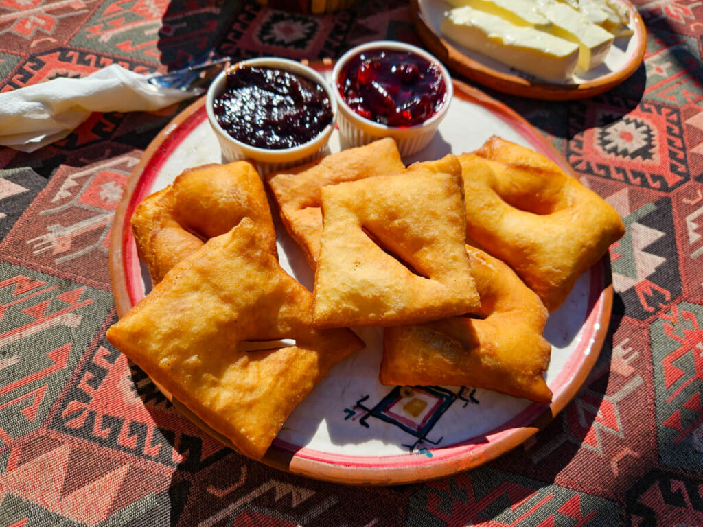 A plate of priganice, friend pastry pockets, served with jam for breakfast in Eko Katun Rosi.