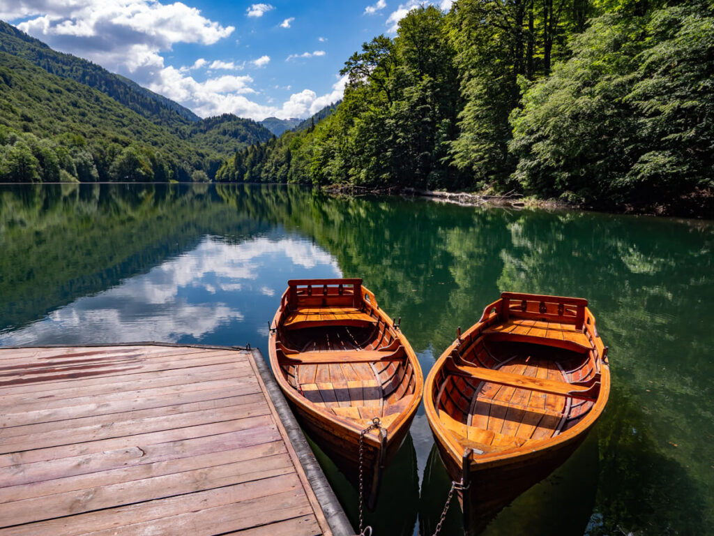 two wooden rowboats moored on the side of a dock on Lake Biograd in Montenegro.