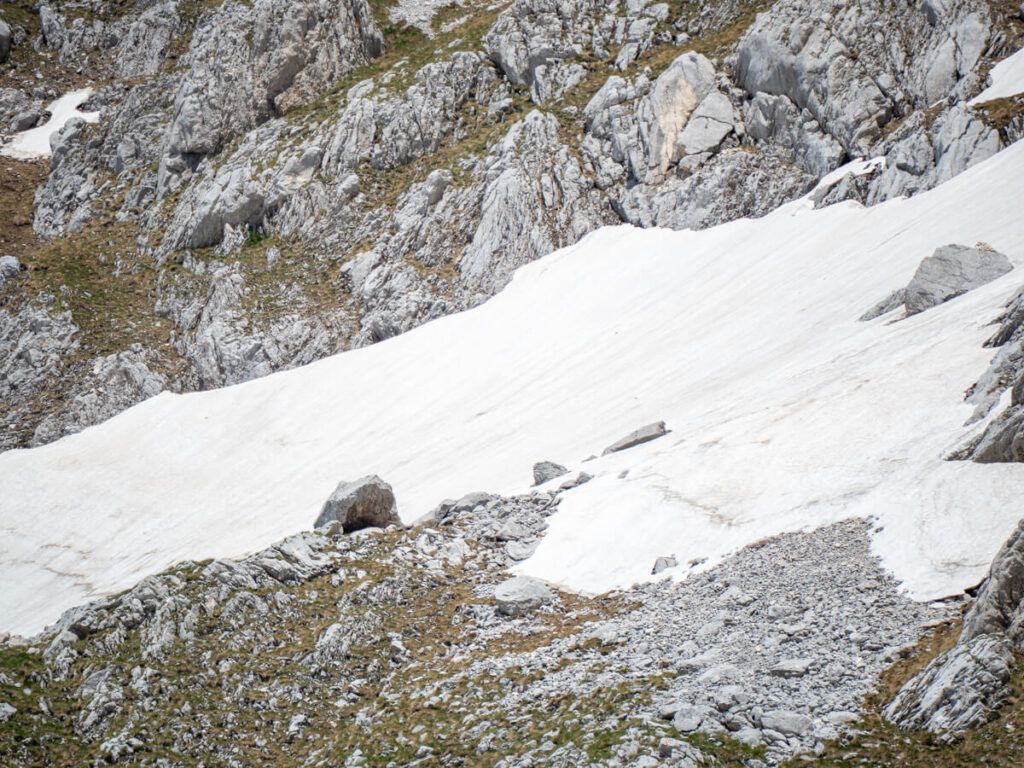 A distant set of footprints through the snow on the steep side of Bobotov Kuk.