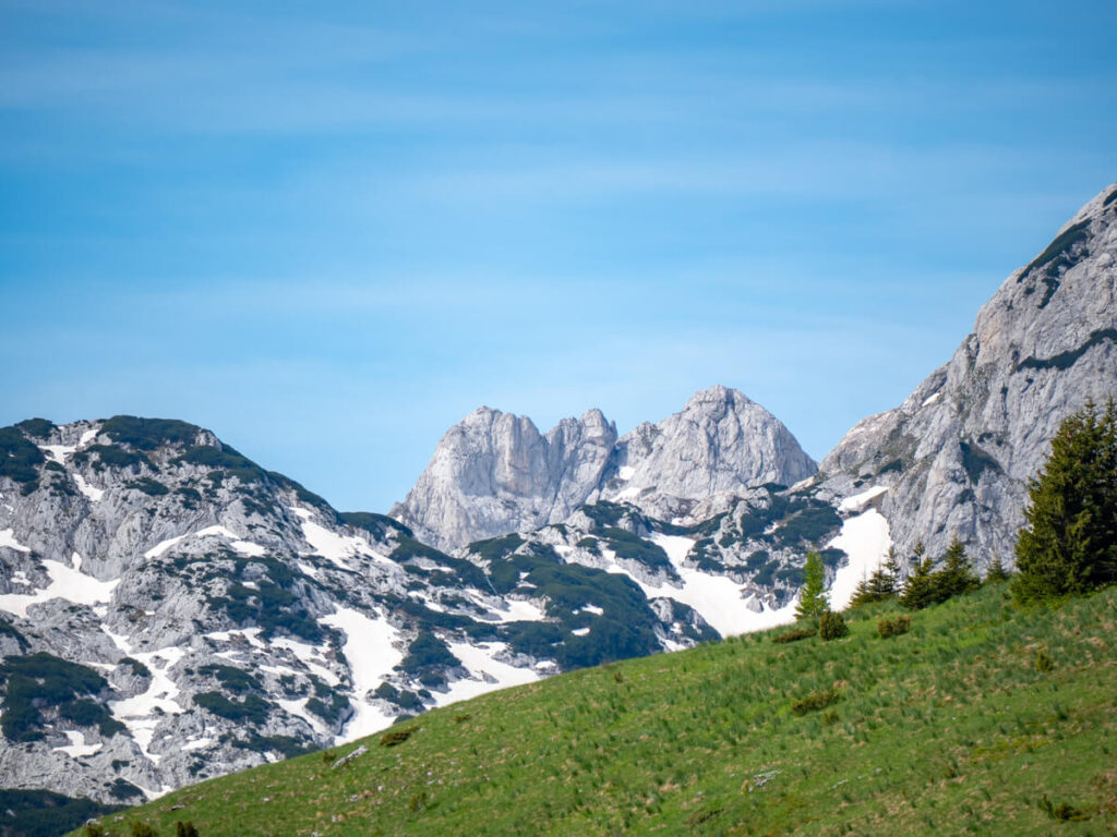 Snowy mountains behind a large green ridge in northern Durmitor National Park.