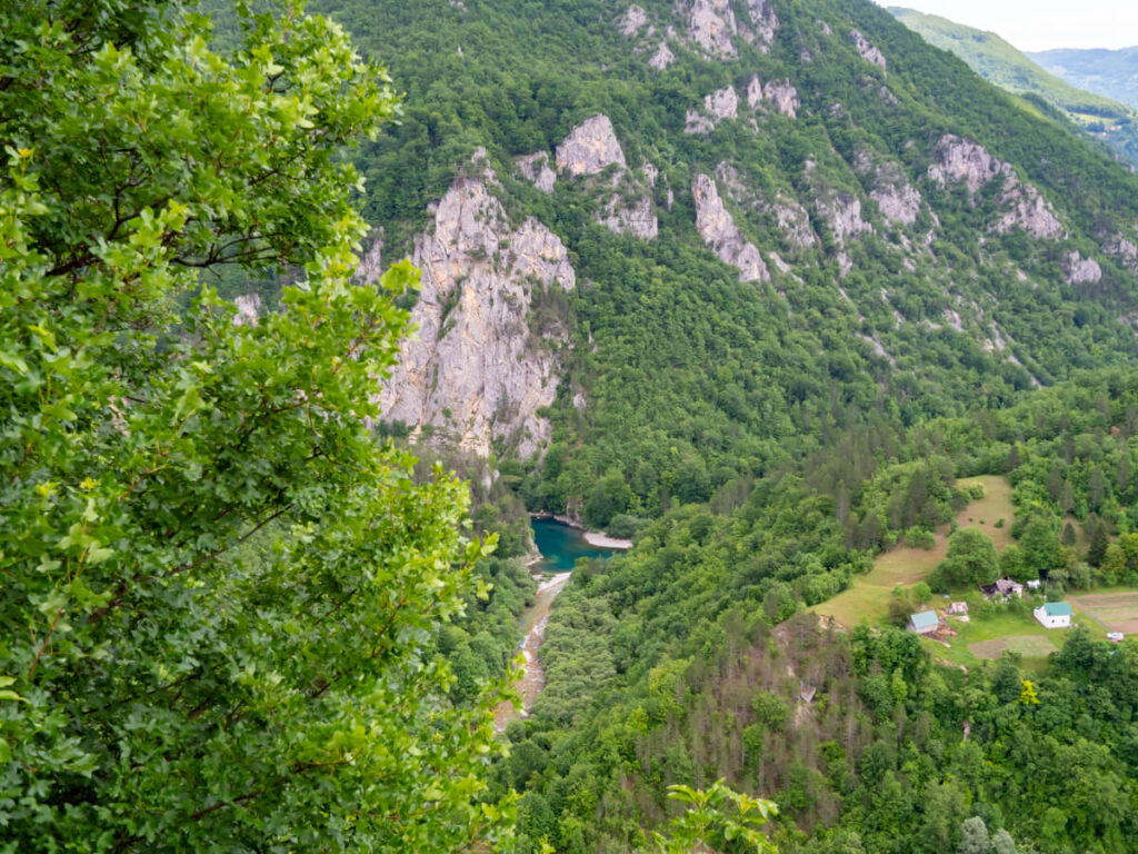 Part of a wide blue river in a remote part of the Tara River Canyon, glimpsed from above.