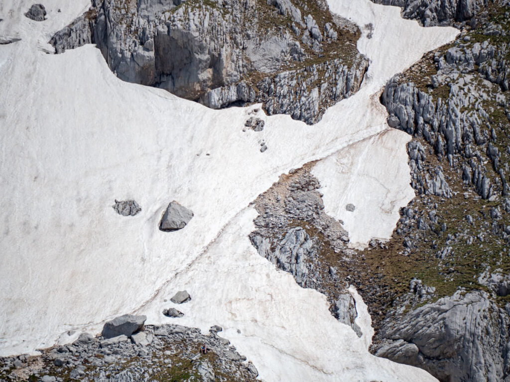 A trail of footprints through snow on the steep side of Bobotov Kuk in Durmitor National Park.