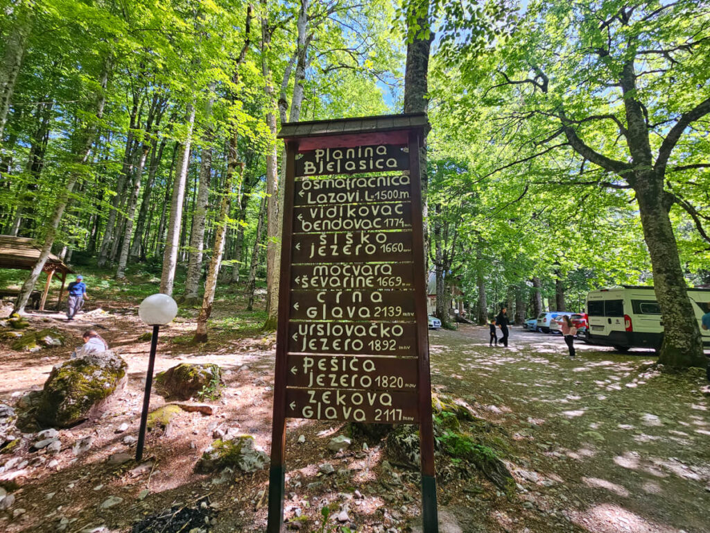 A sign indicating the way to various hiking trails in Biogradska Gora National Park.