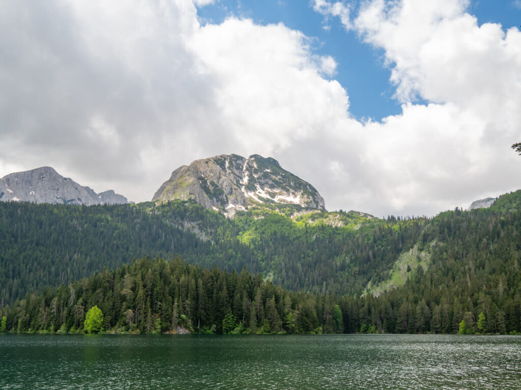 A snowy peak above the calm waters of the Black Lake in Durmitor National Park.
