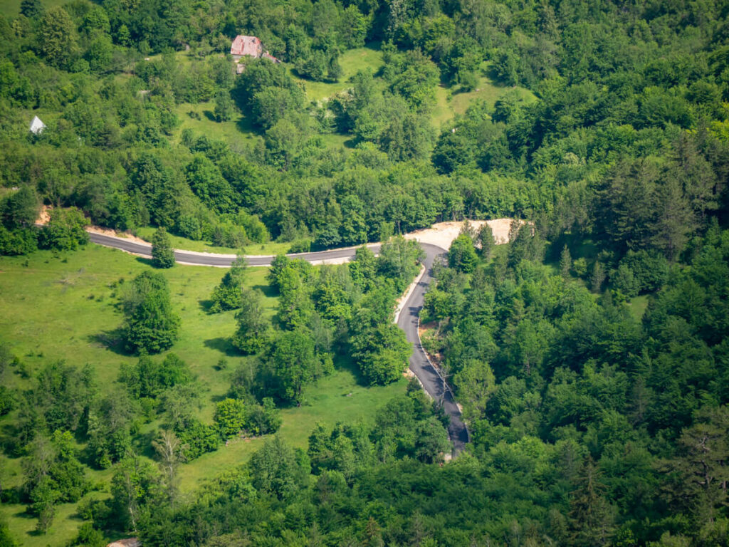 A winding road surrounded by greenery, viewed from Ćurevac Peak.