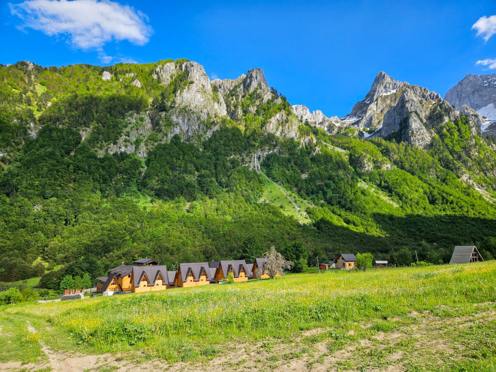 Cabins belonging to Eco Lux Prokletije set against the mountains of the Grebaje Valley, viewed from one of the Three Peaks trailheads.
