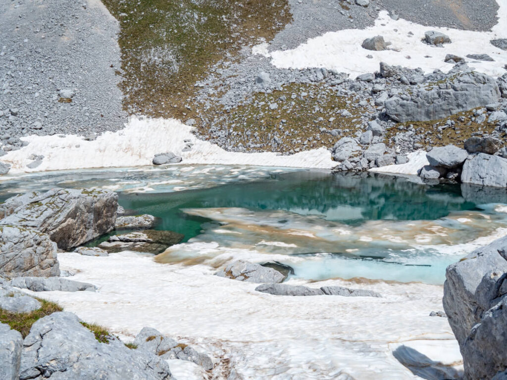 The icy blue water of Zeleni Vir Lake surrounded with snow.