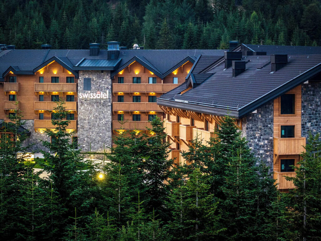SwissĂ´tel Resort Kolasin in Biogradska Gora lit up at night time.