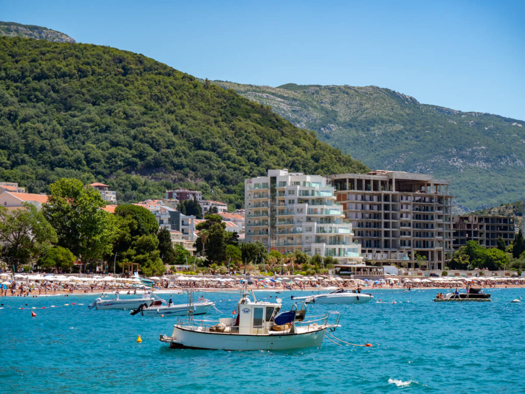 Boats bobbing in the bay in front of the ebach, lined with hotels in Petrovac.