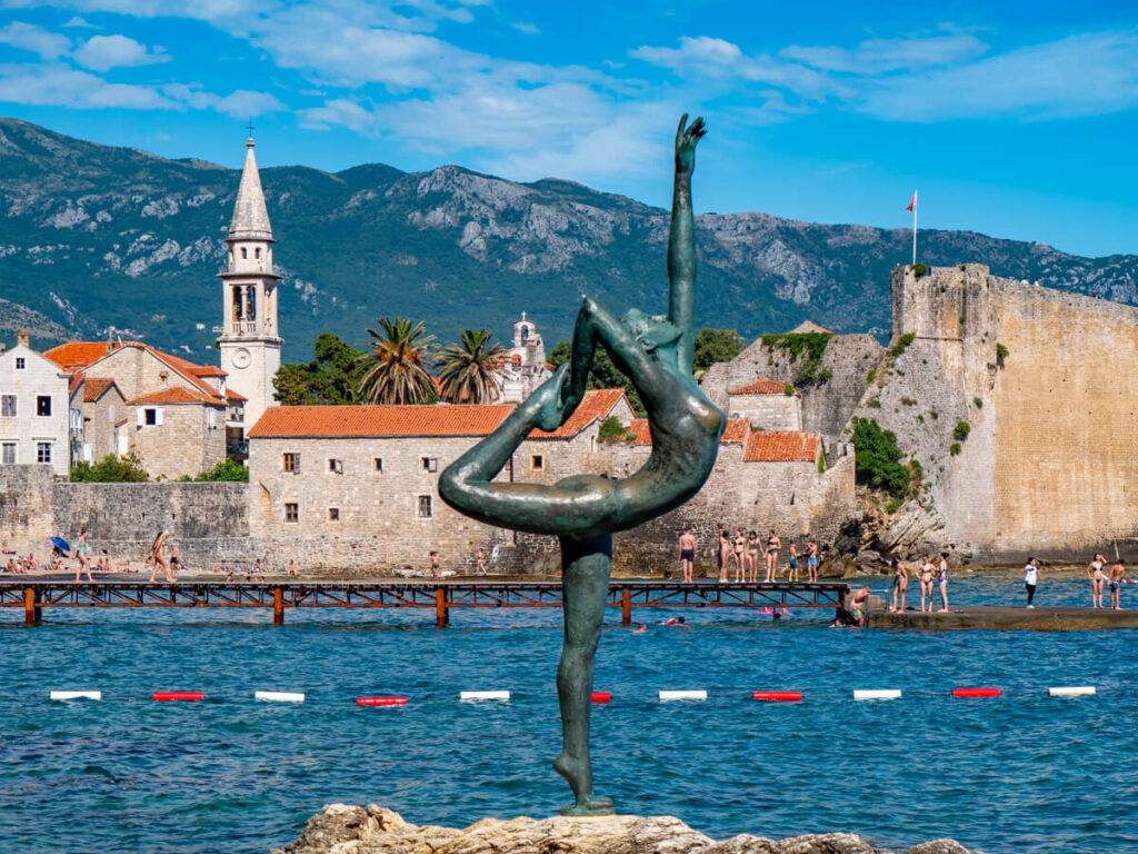 The ballerina statue in front of the terracotta rooftops of Budva Old Town.