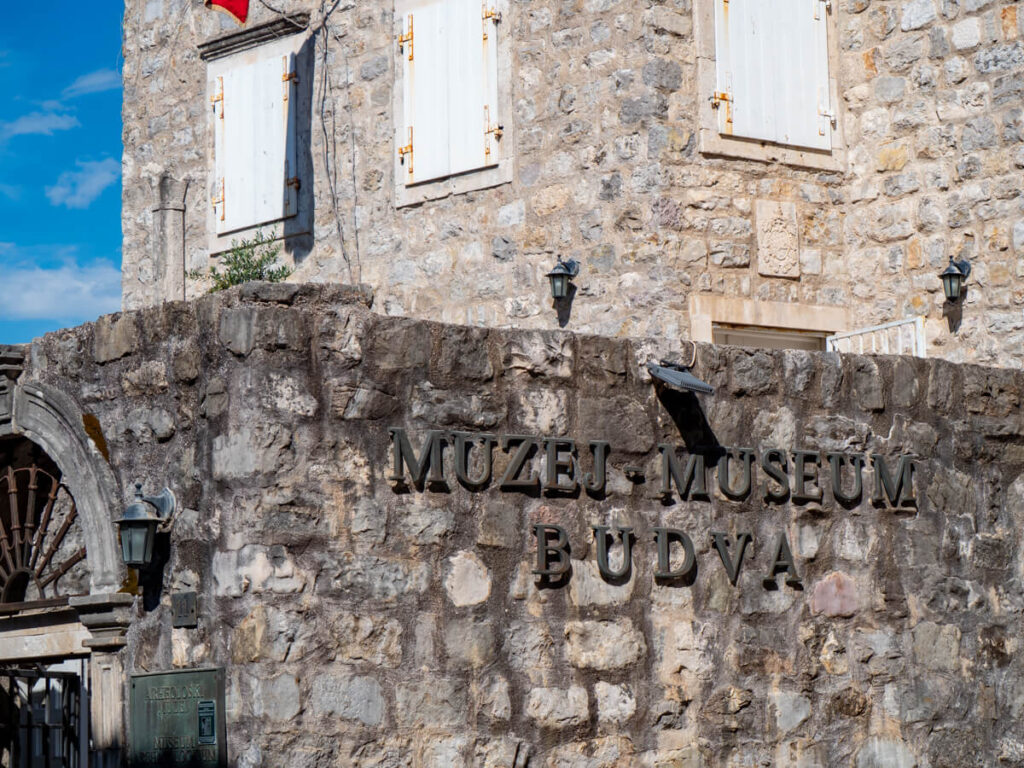 A metal sign on a stone building for the Budva Museum.