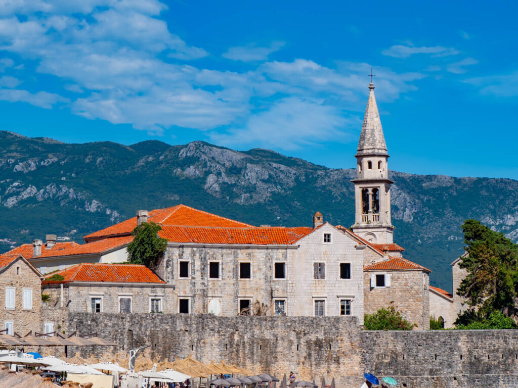 A church spire towering over the red rooves of Budva Old Town.