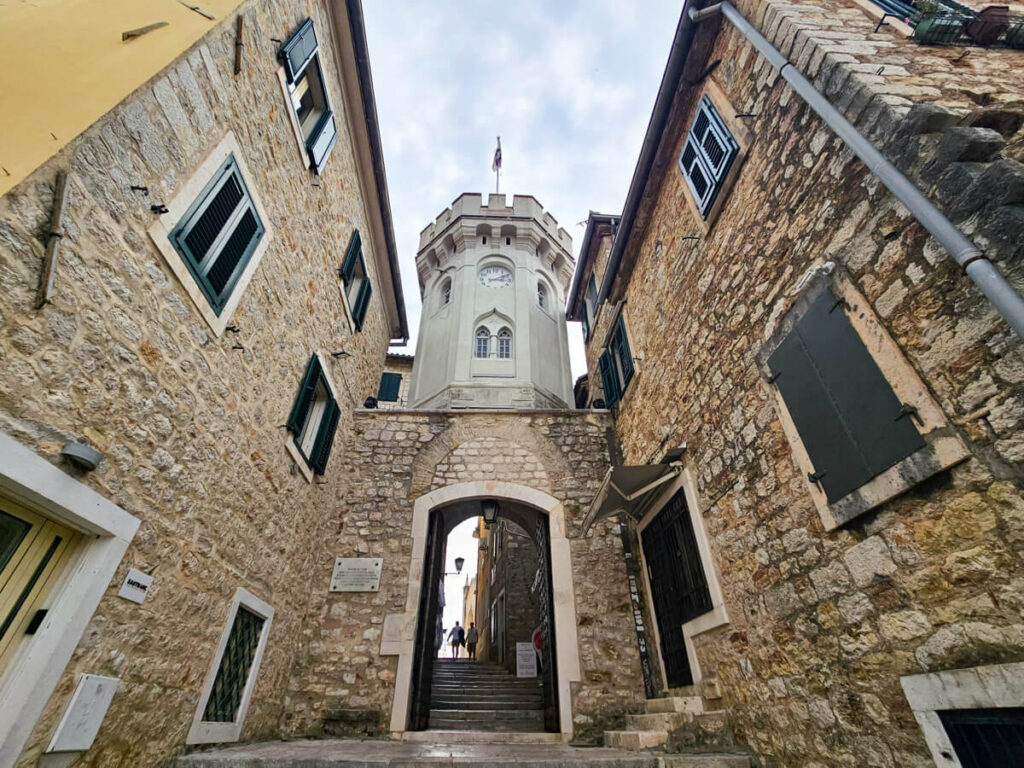 A stone archway underneath the clock tower in the old town of Herceg Novi.
