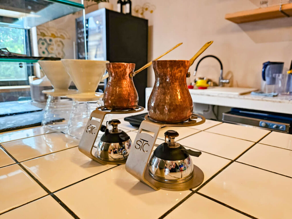 Traditional copper coffee pots next to some more modern V60 coffee makers in Koffein Speciality Coffee Shop.