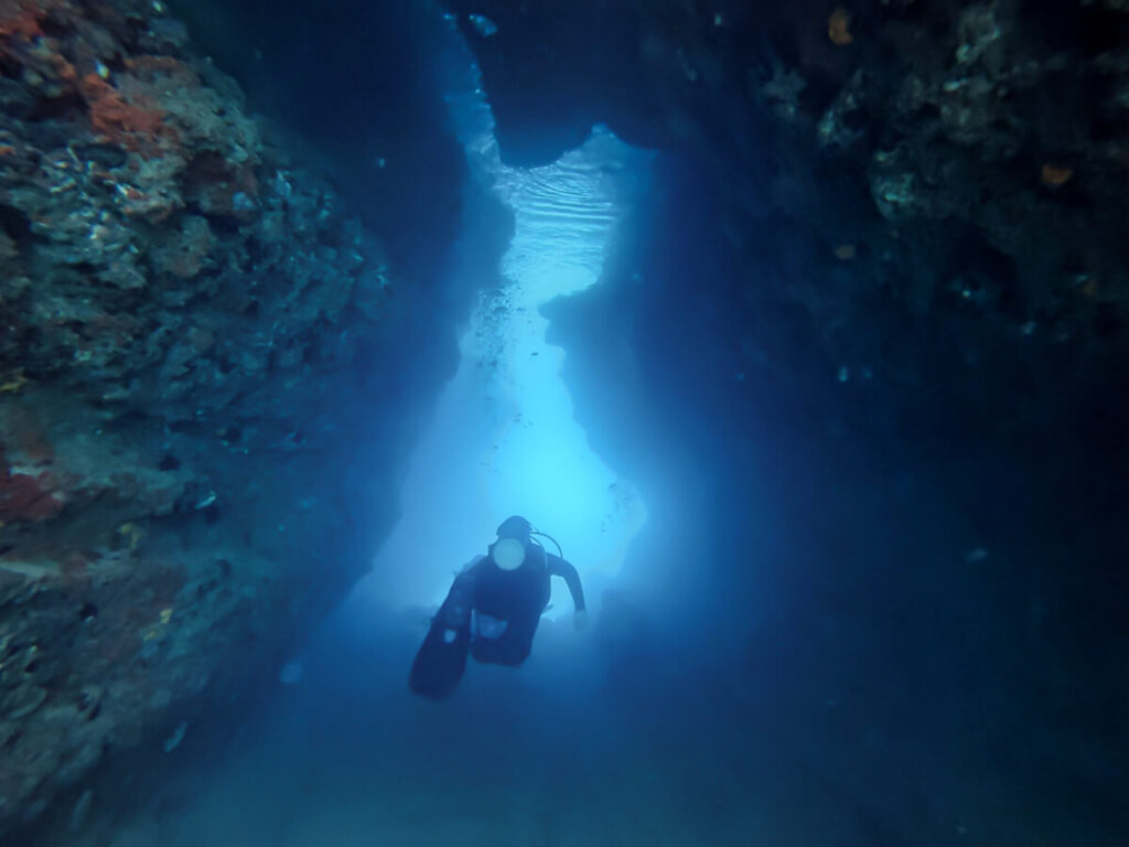 Dan SCUBA diving through a dark tunnel near Budva, Montenegro.