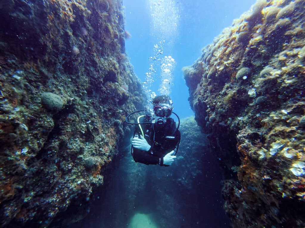 Dan SCUBA diving between two walls in Budva, Montenegro.