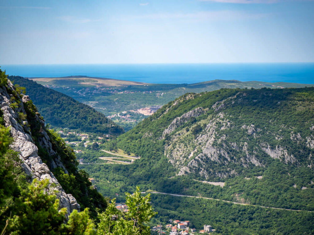 The Kotor Serpentine road snaking in a valley in the distance, viewed from the Ladder of Kotor.