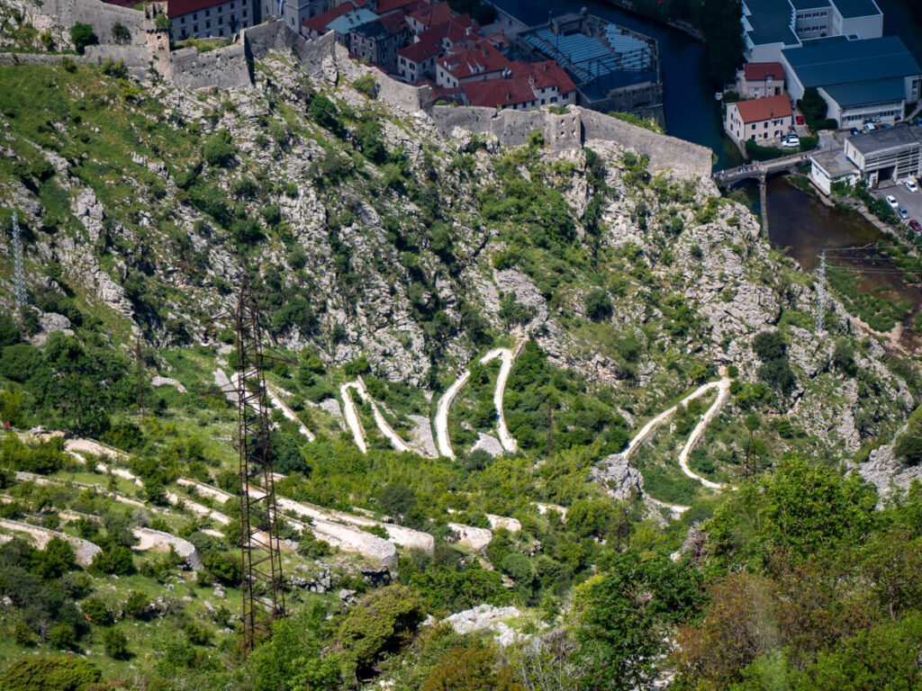 A series of tight switchbacks on a rocky trail in the mountainside on the Ladder of Kotor.