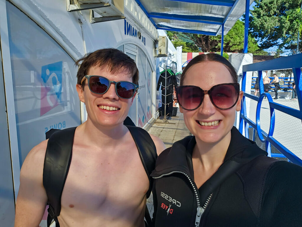 Lucy in a wetsuit and Dan in sunglasses smiling at Budva Diving Center.