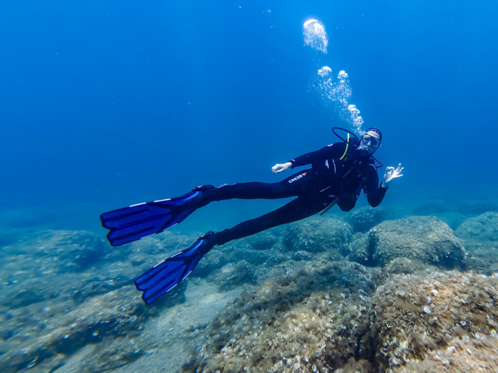 Lucy making the ok symbol with her hand while SCUBA diving in Budva, Montenegro.