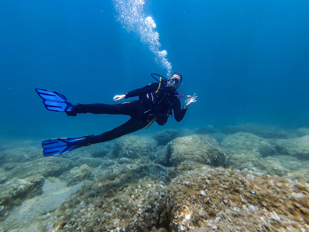 Lucy making the 'OK' sign while SCUBA diving in Montenegro.