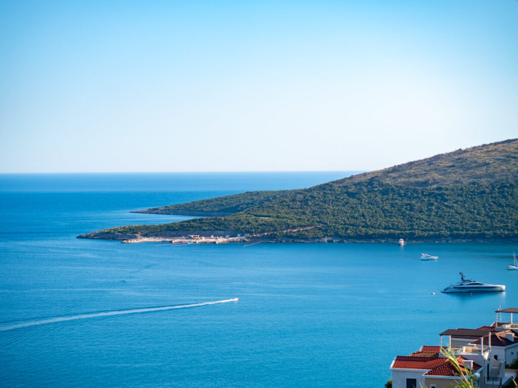 A hotel overlooking the Adriatic Sea and a moored yacht off the Luštica Peninsula.