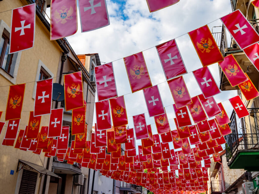 Old and new Montenegrin flags strung above a street in Cetinje.