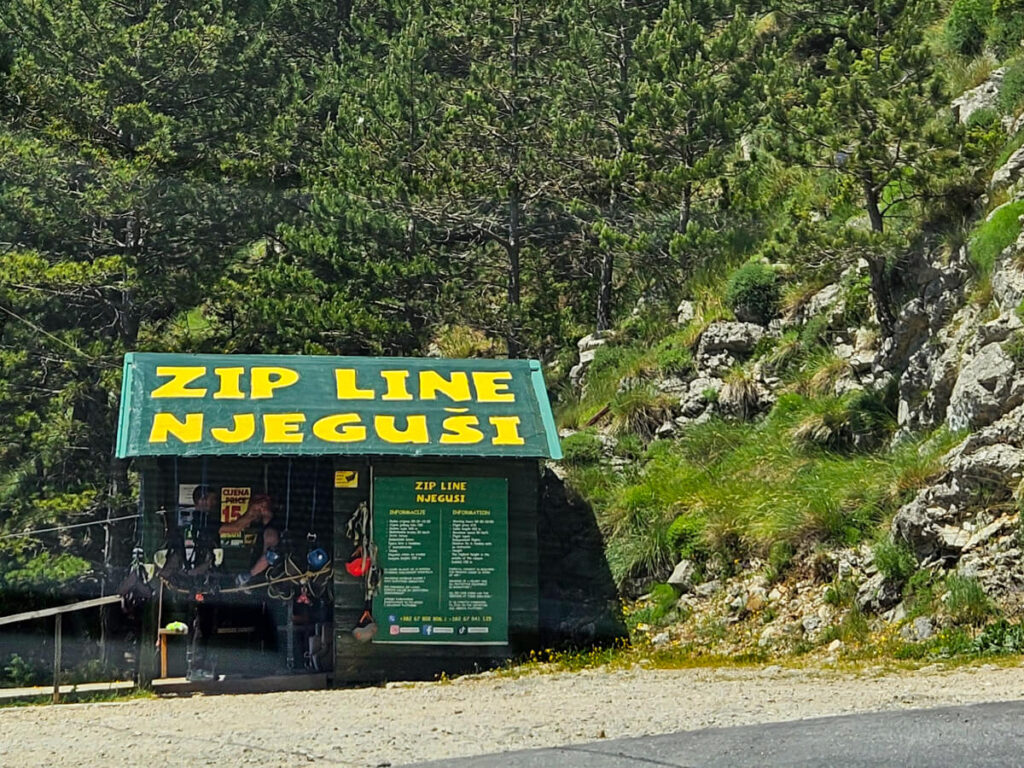 A shed with equipment and writing advertising a zipline in Njeguši.