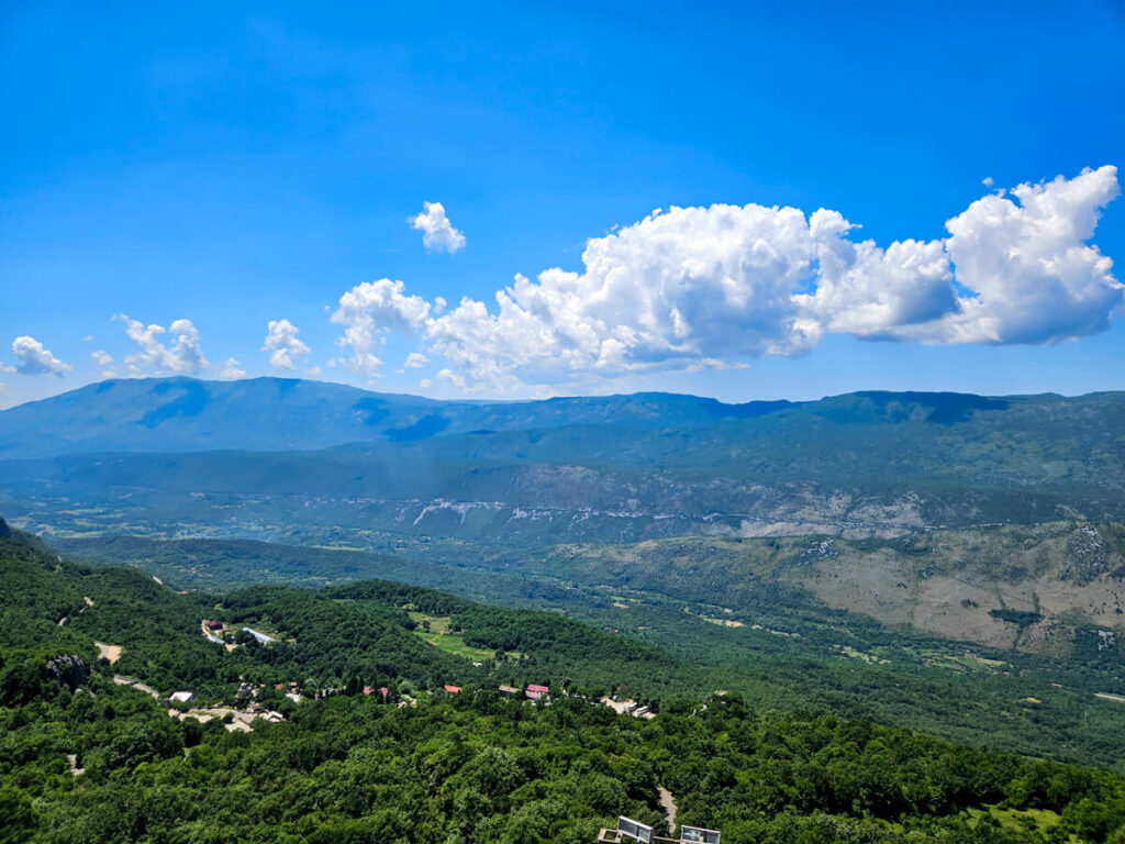 A panoramic view of a lush green valley, seen from Ostrog Monastery.