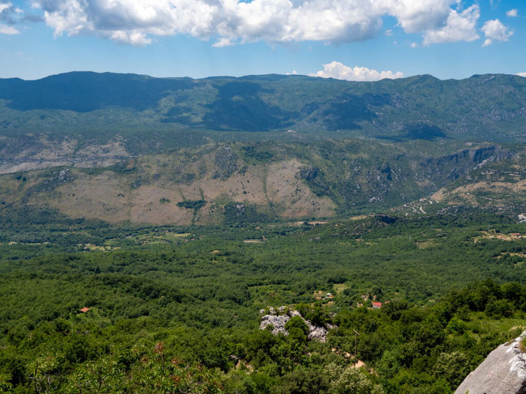 A view of a lush green valley, taken from the Upper Monastery at Ostrog Monastery.