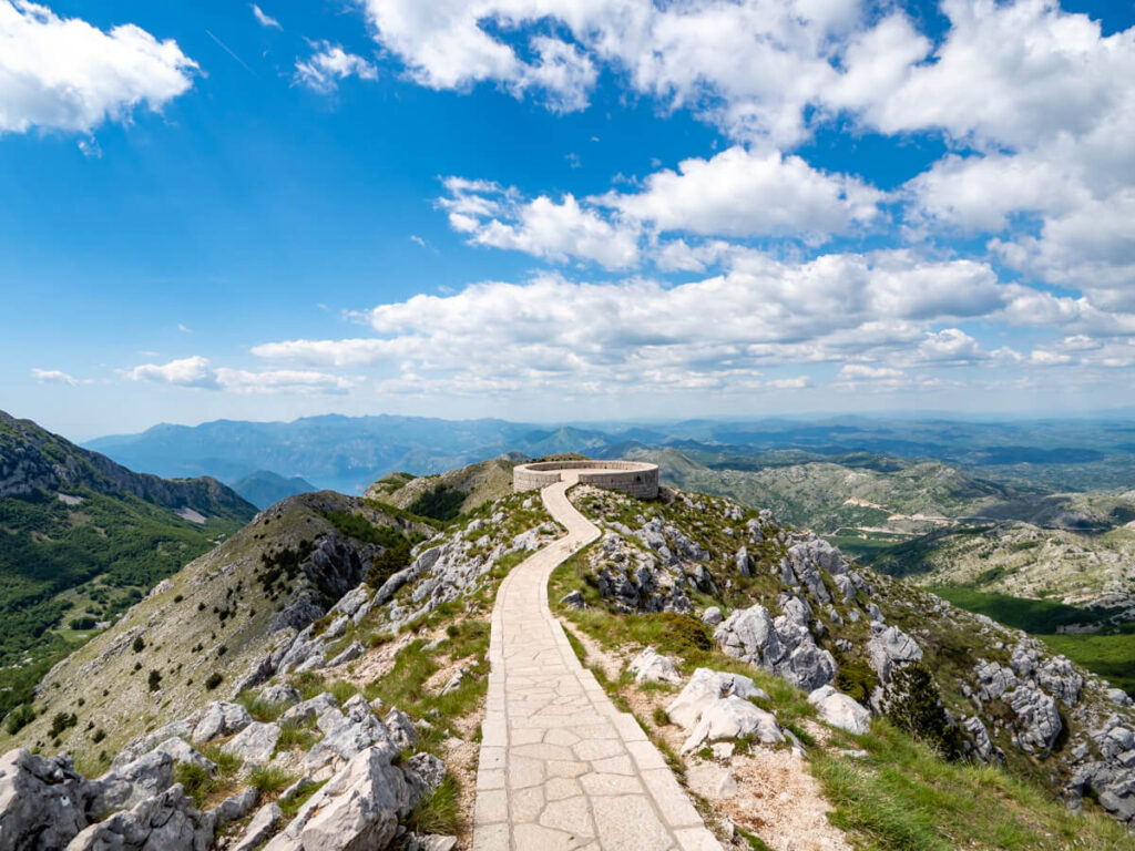 A narrow paved path leading to a circular viewpoint in Lovćen National Park.