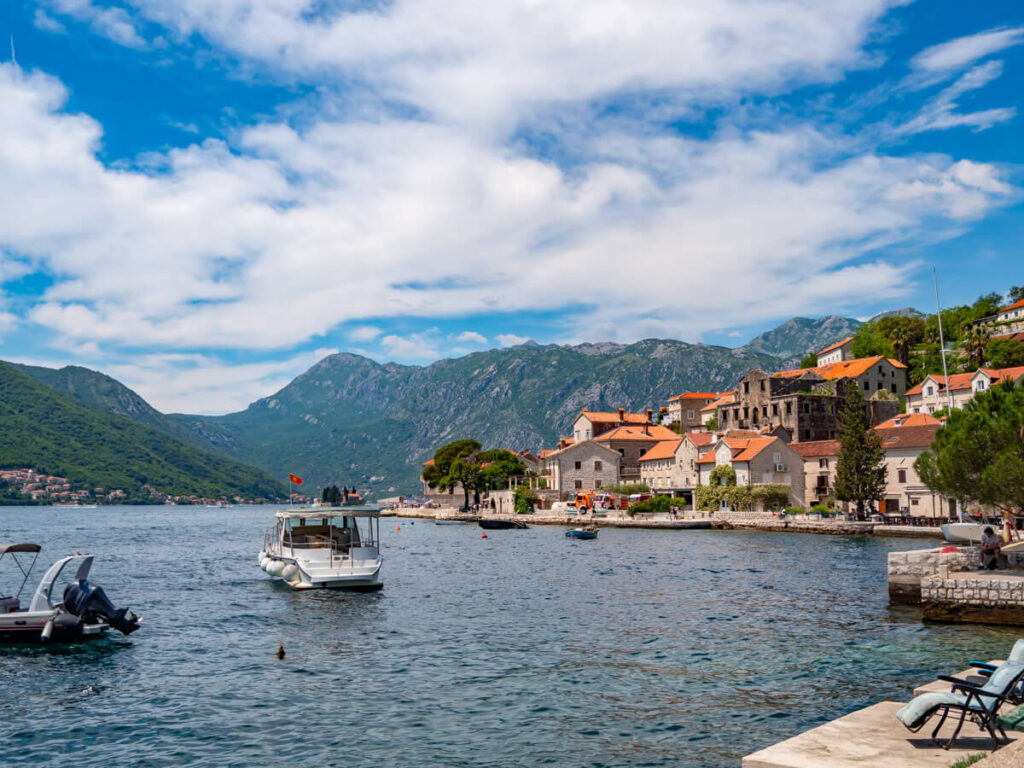 The waterfront of Perast, lined with stone houses.