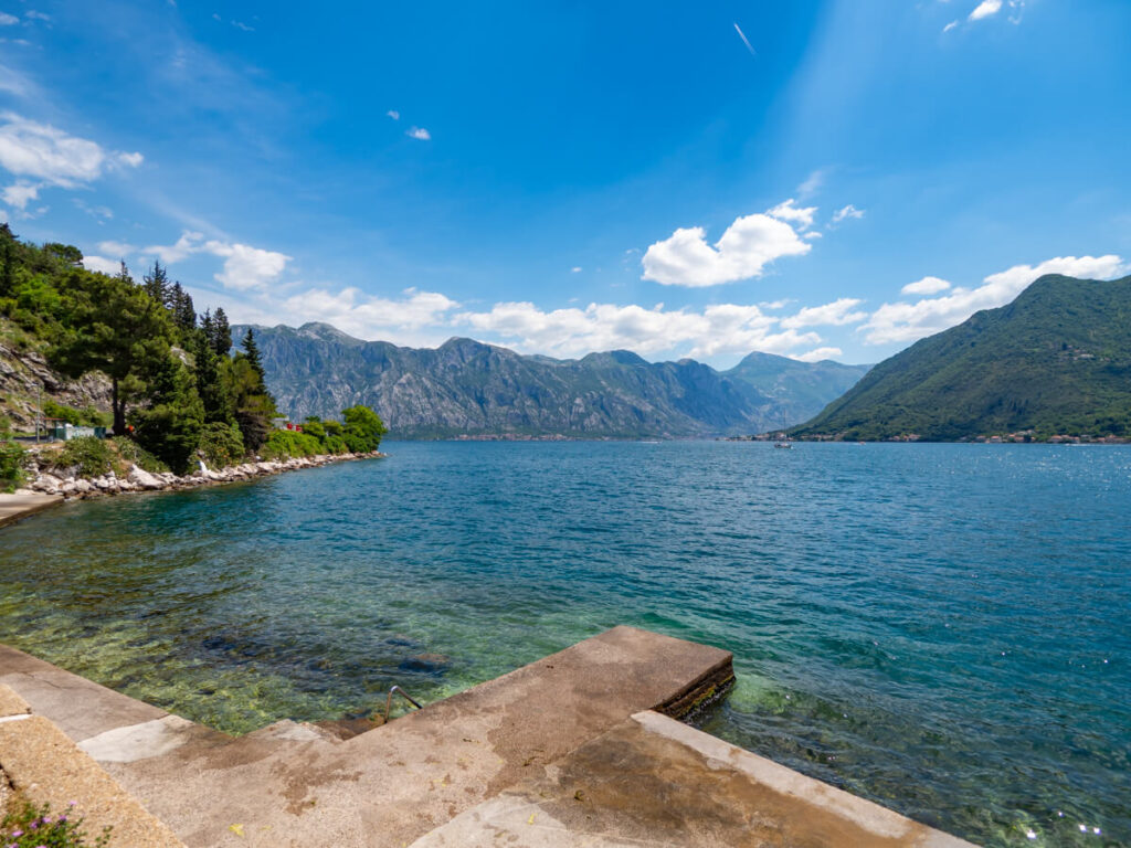 A concrete platform jutting into the clear water of the Bay of Kotor near Perast.